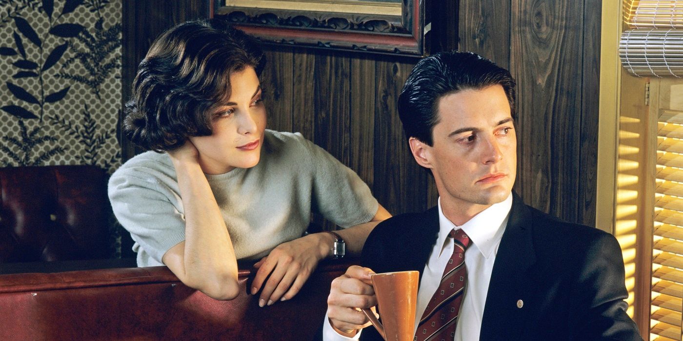 Audrey looks at Special Agent Dale Cooper as he looks out the window in Twin Peaks.