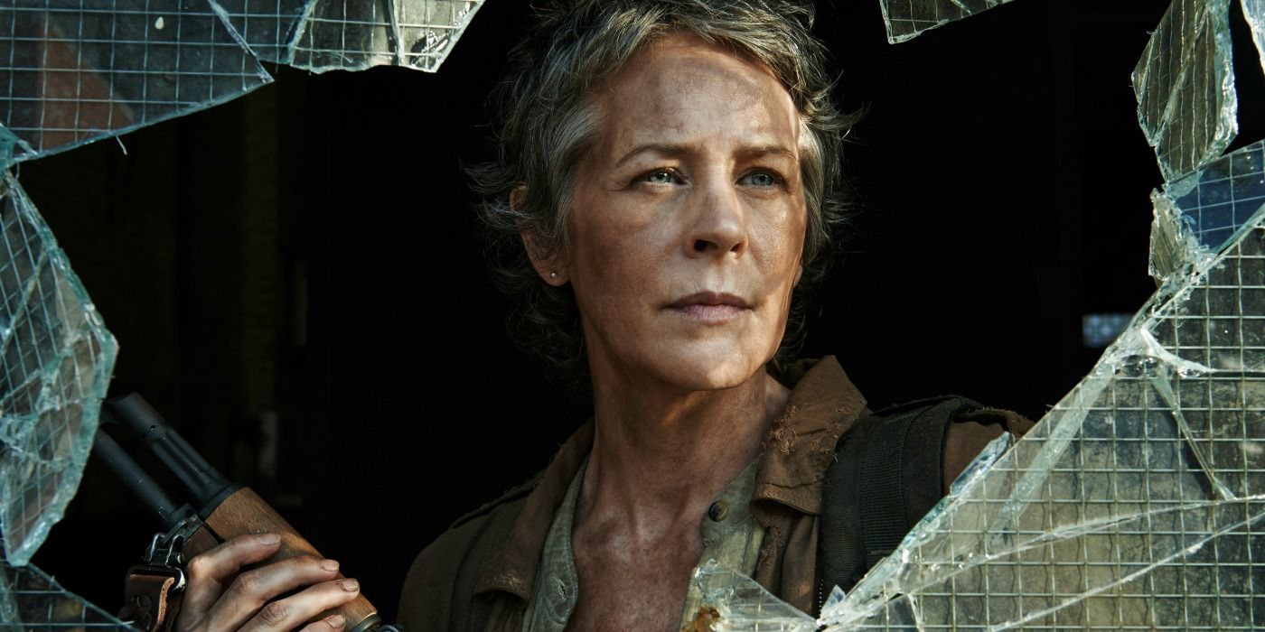 Carol from The Walking Dead standing inside shattered glass with a gun, looking ready to fight.