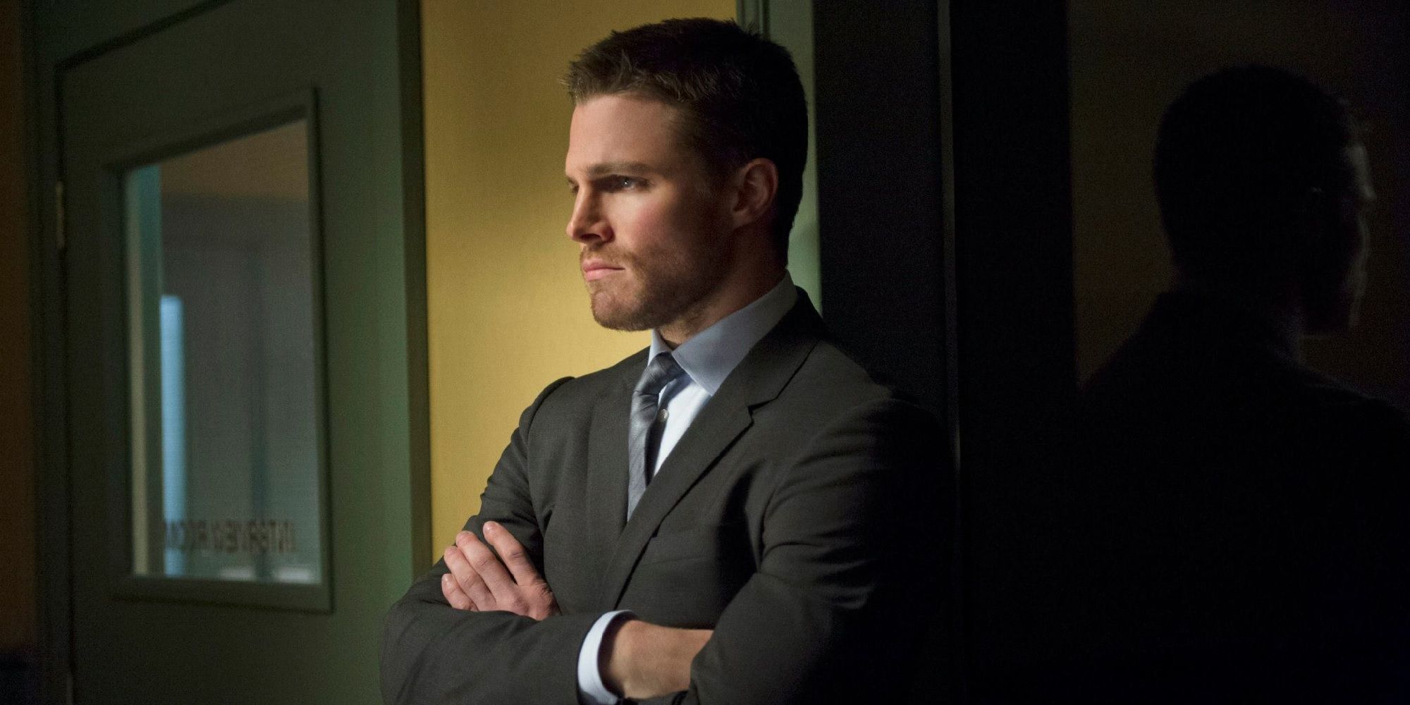 Oliver Queen stands with his arms crossed in Arrow
