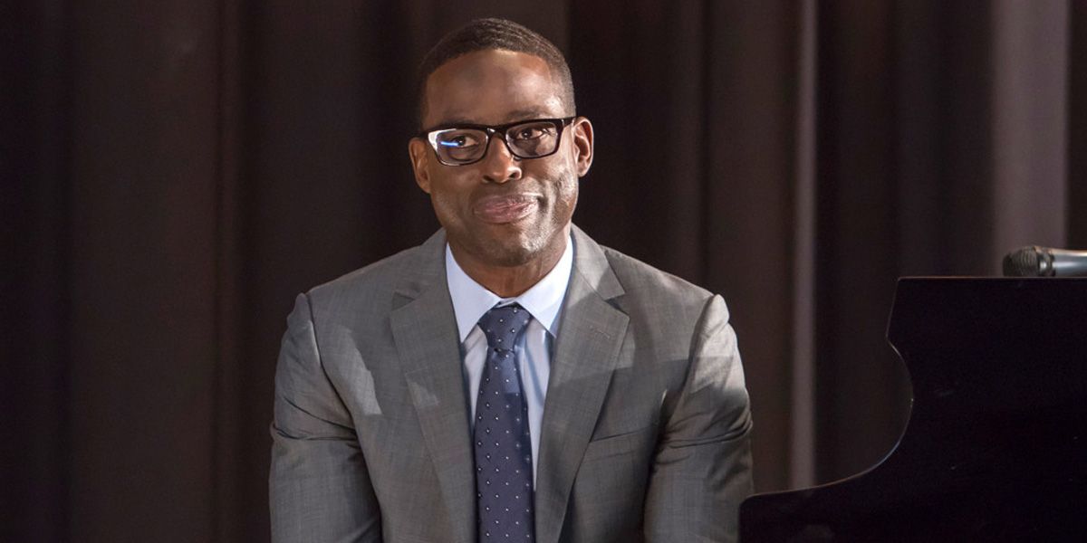 Sterling K Brown smiling coyly in a suit