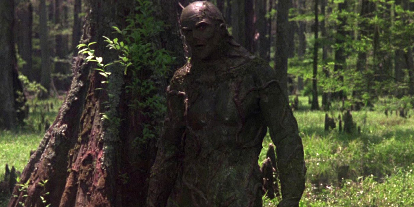 Live-action Swamp Thing standing in front of a tree in the 1982 Swamp Thing movie.
