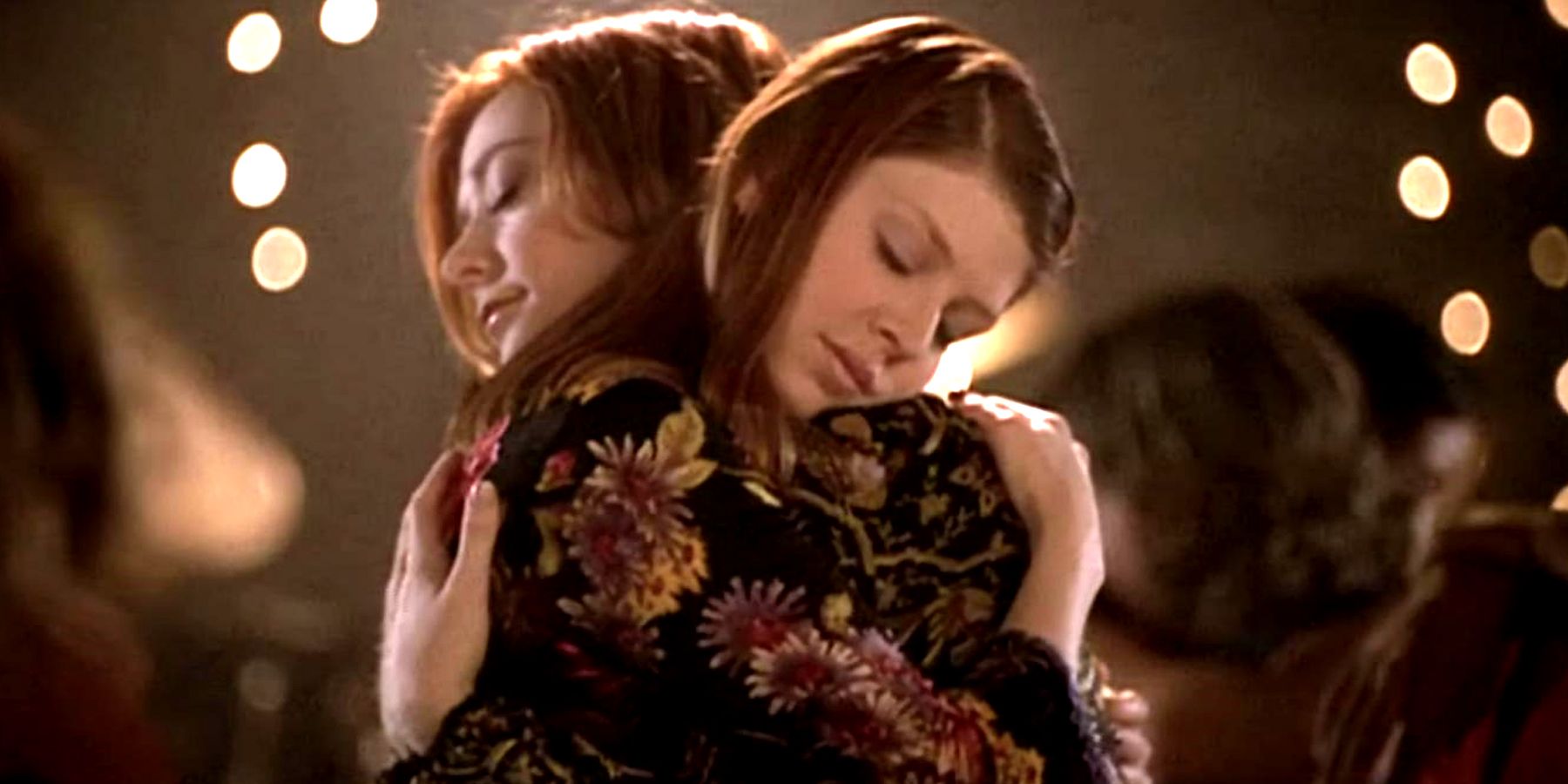Willow and Tara have their eyes closed as they hug each other in Buffy the Vampire Slayer