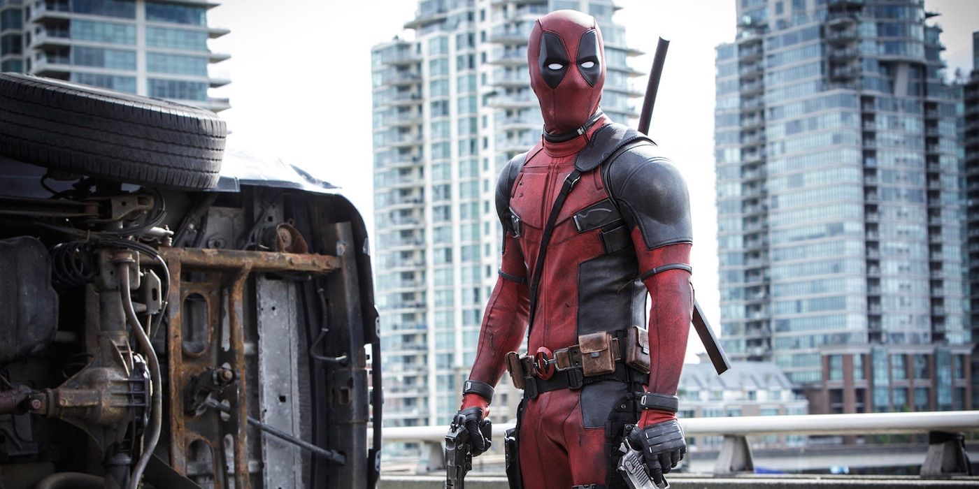 Deadpool standing in the city holding a gun