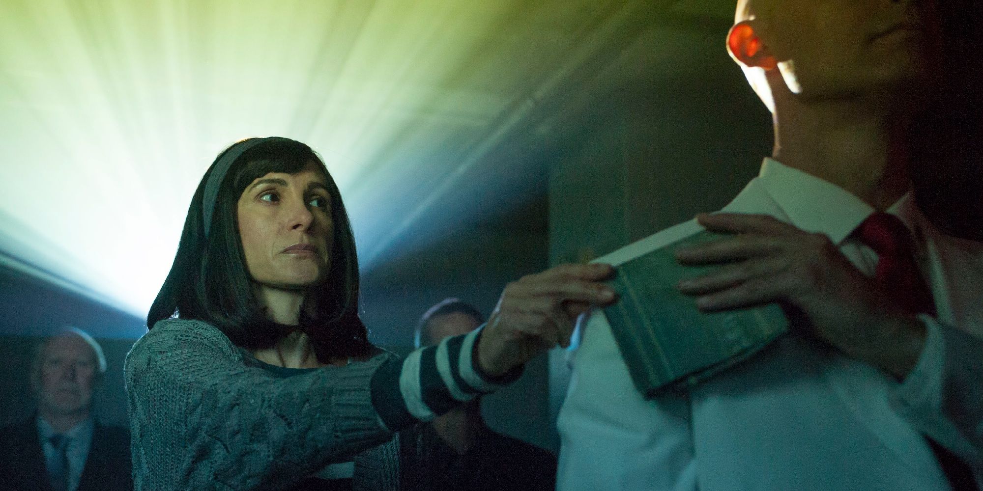 Danni handing off papers to a mysterious figure in Preacher