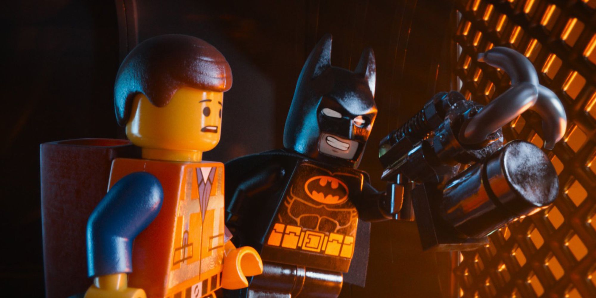 Emmet ve Batman, Lego filminde metal bir çitin yanında yan yana duruyor.