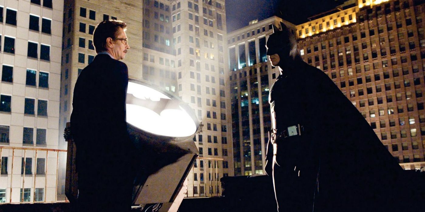 Jim Gordon and Batman in front of Bat-signal