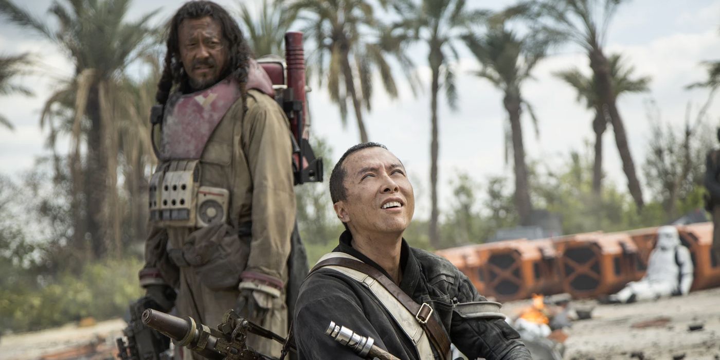 Chirrut Imwe smiles and looks up while Baze Malbus stands behind him in Rogue One: A Star Wars Story