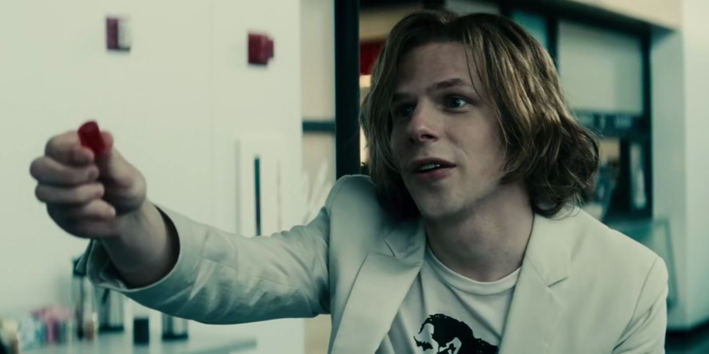 Jesse Eisenberg as Lex Luthor holding out a Jolly Rancher