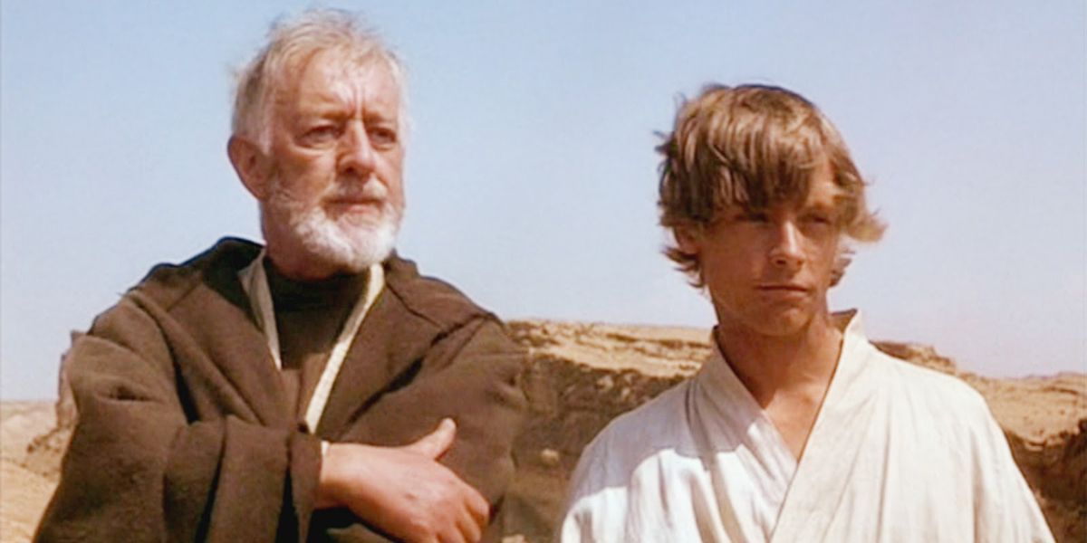 Obi-Wan and Luke Skywalker look off in the distance, with desert scenery behind them