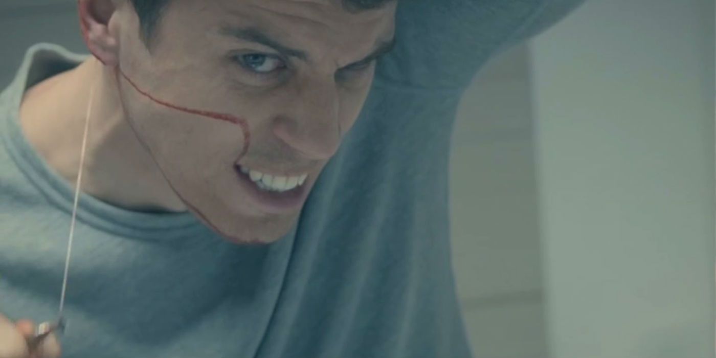 A man cutting his face open in the mirror in a scene from Black Mirror.