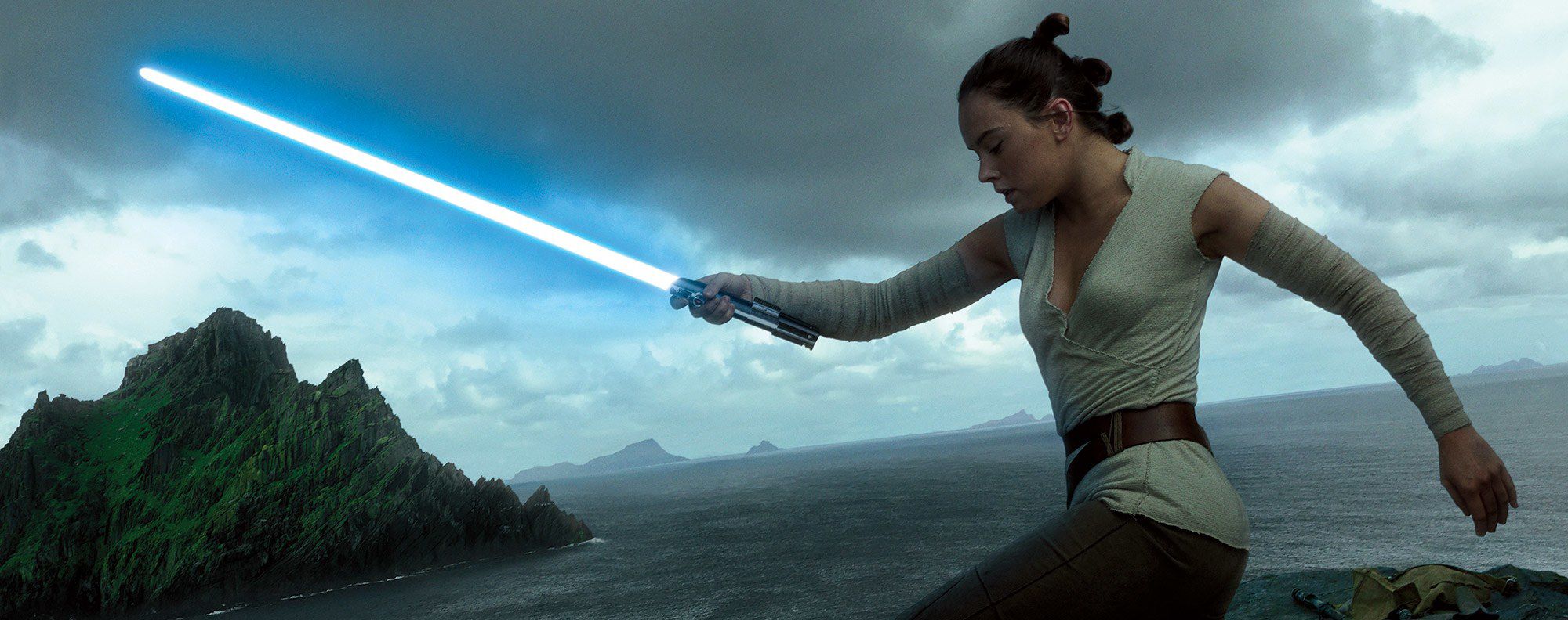 Rey holding Luke Skywalker's Lightsaber