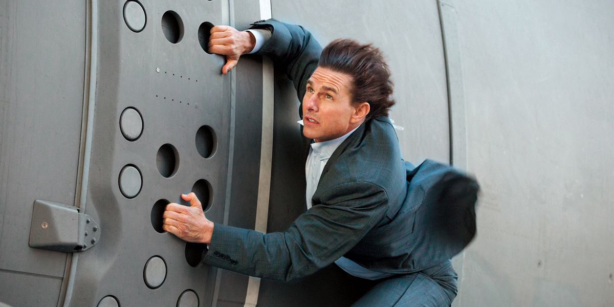Tom Cruise's Ethan Hunt hangs onto the side of a plane in Mission: Impossible - Rogue Nation