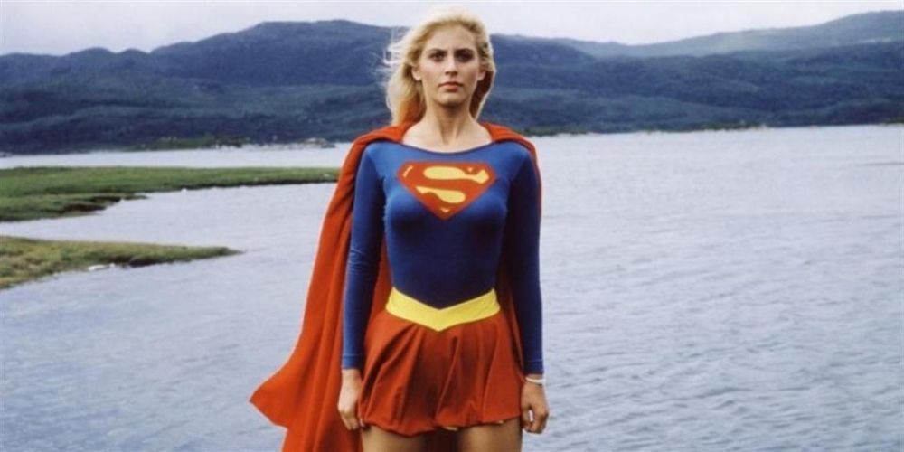 Helen Slater as Supergirl standing in front of a lake.