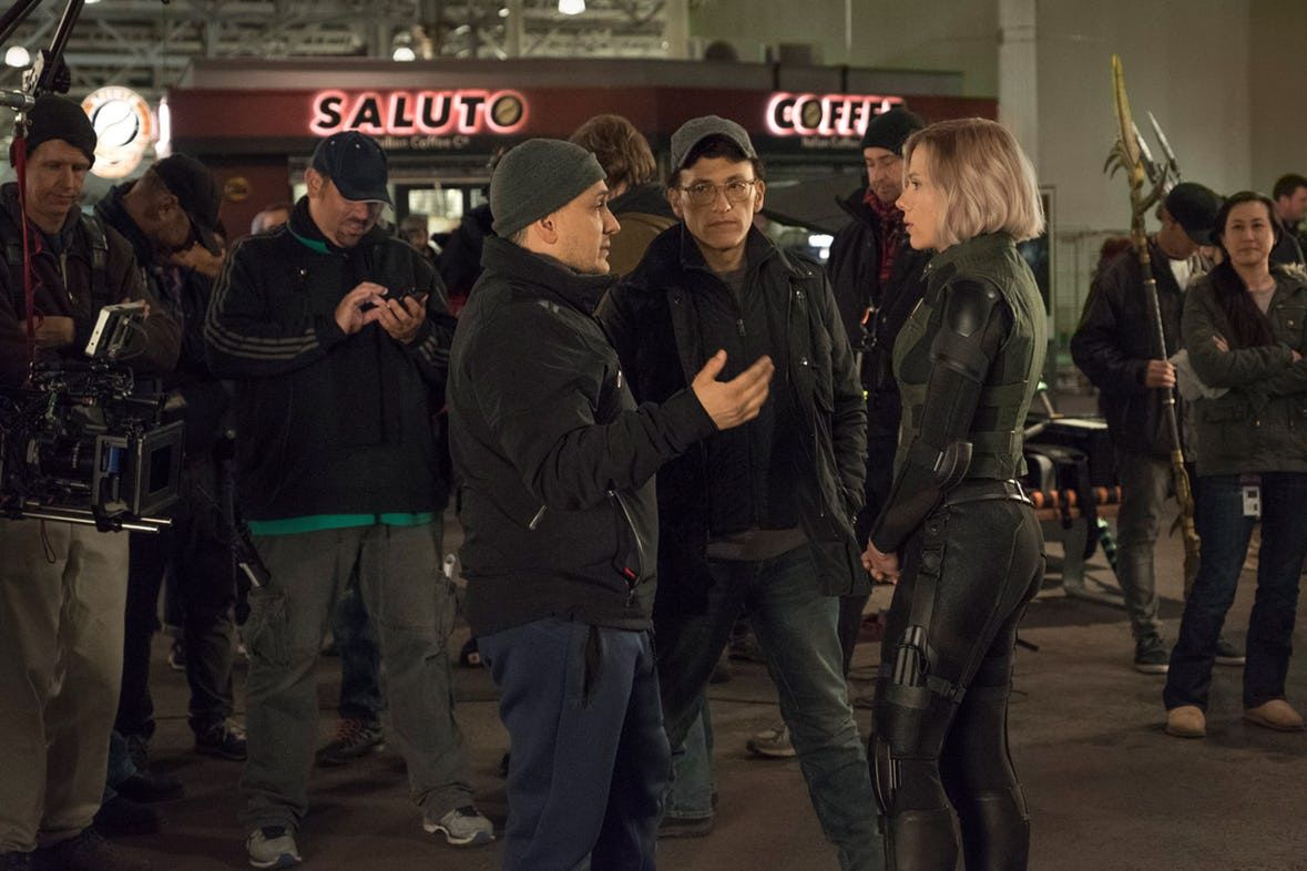 Scarlett Johansson, Joe and Anthony Russo huddle in a new Avengers: Infinity War set photo.
