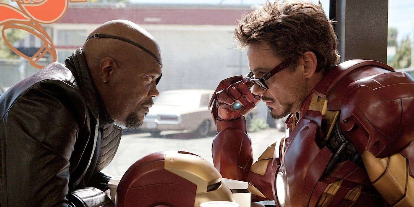 Tony Stark tilts his sunglasses down as he sits with Nick Fury at a diner table