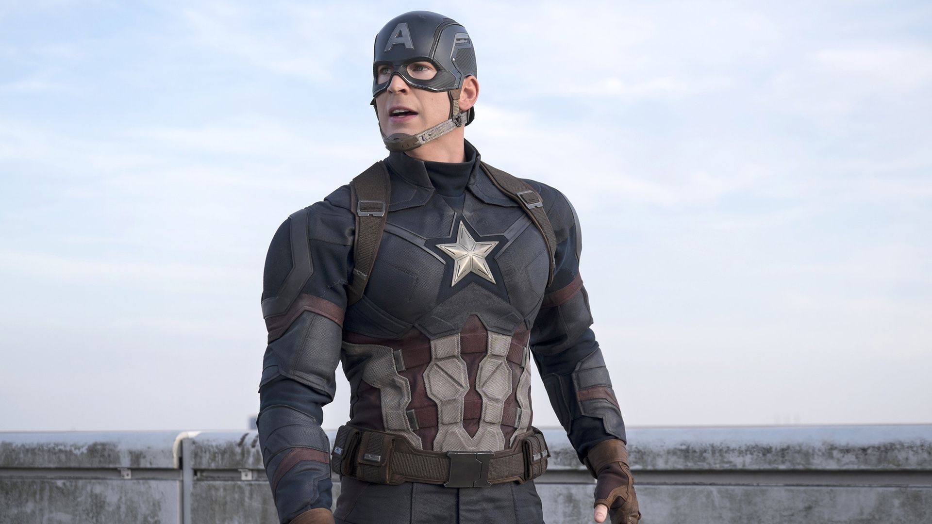 Captain America stands in front of a waist-high wall, looking off into the distance