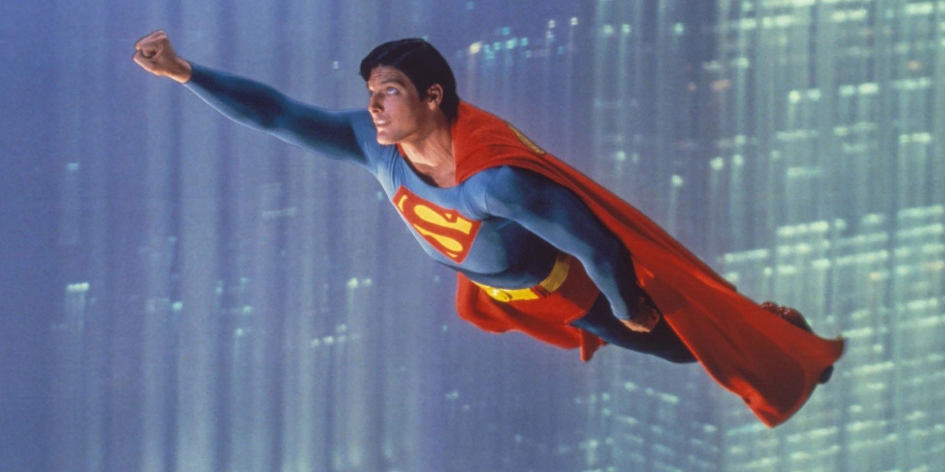 Christopher Reeve in Superman: The Movie taking flight with his right arm raised.
