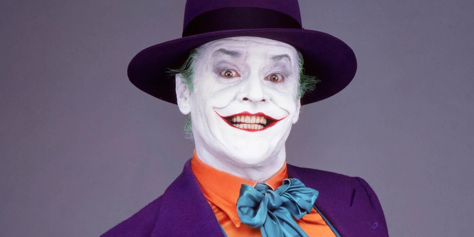 Jack Nicholson puts on a wide smile in Joker makeup