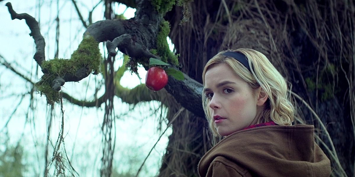 Sabrina olha para trás, diante de uma maçã pendurada em O Mundo Sombrio de Sabrina.