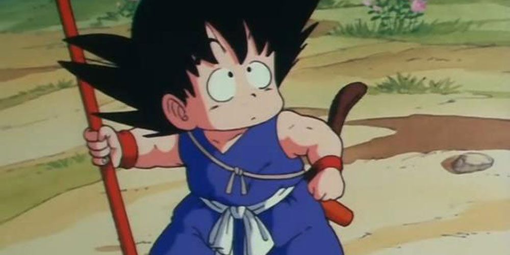 Eleven-year-old Goku holding a staff and looking upward apprehensively