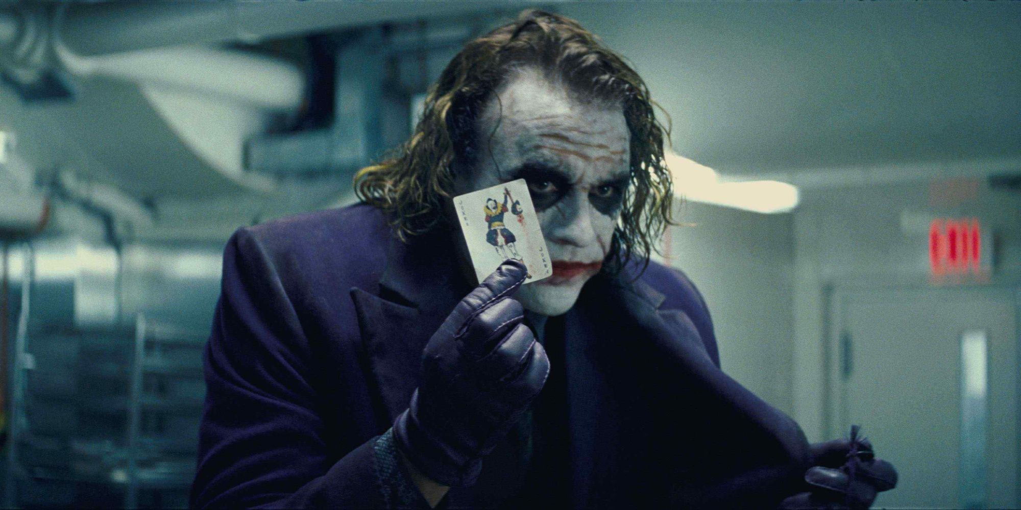 The Joker holding a card in The Dark Knight