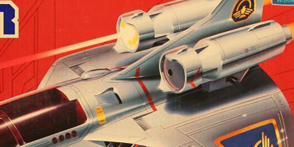 A laser light shines from the top of a vehicle on the box of a Captain Power toy.