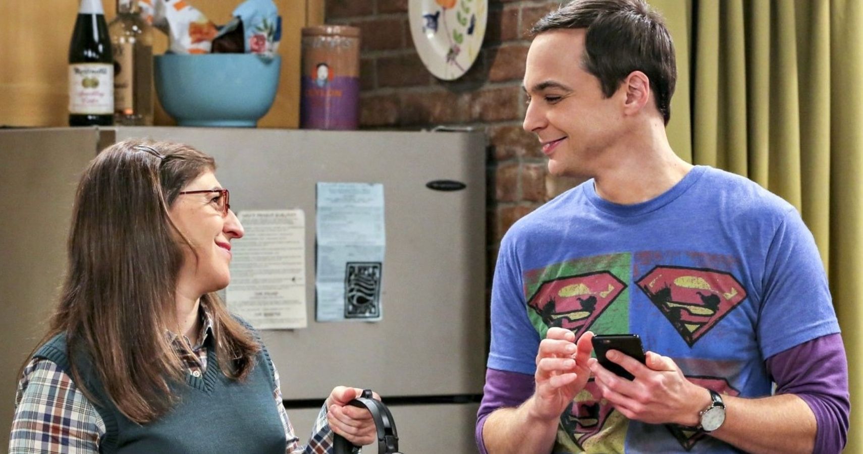 Amy Farrah Fowler and Sheldon Cooper smile at each other on The Big Bang Theory