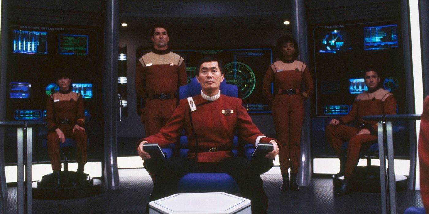 Sulu (played by George Takei) sits in the captain's chair, surrounded by his crew