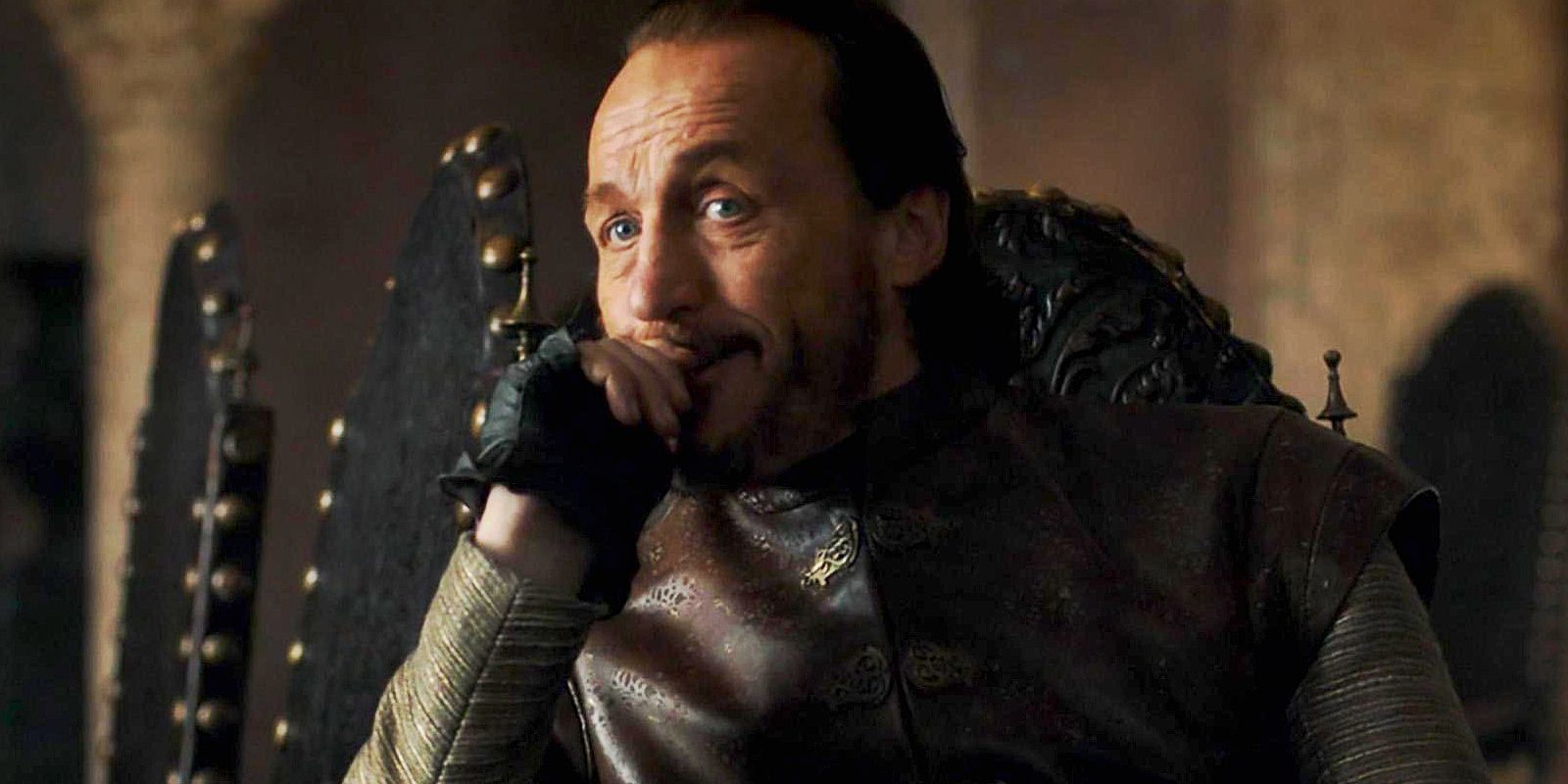Bronn looking amused while sitting on a chair