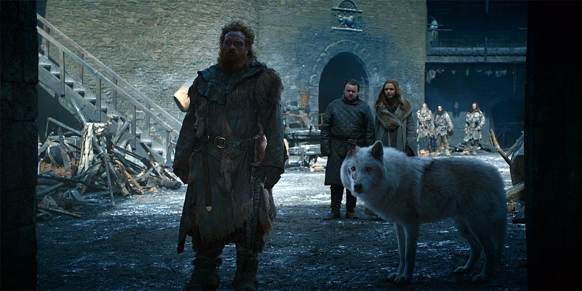Ghost, Tormund, Sam, and Gilly standing around in Game of Thrones.