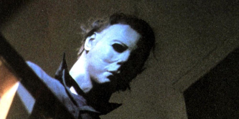 Michael Myers looks over a stair railing in Halloween