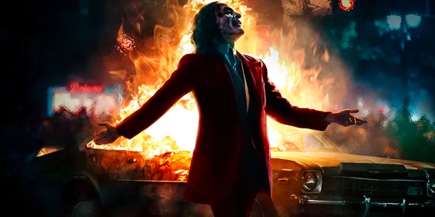 The Joker stands in front of a burning car in Joker.