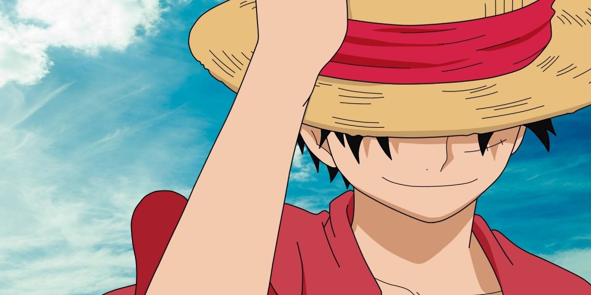 Monkey D. Luffy holding his iconic Straw Hat and smiling during One Piece