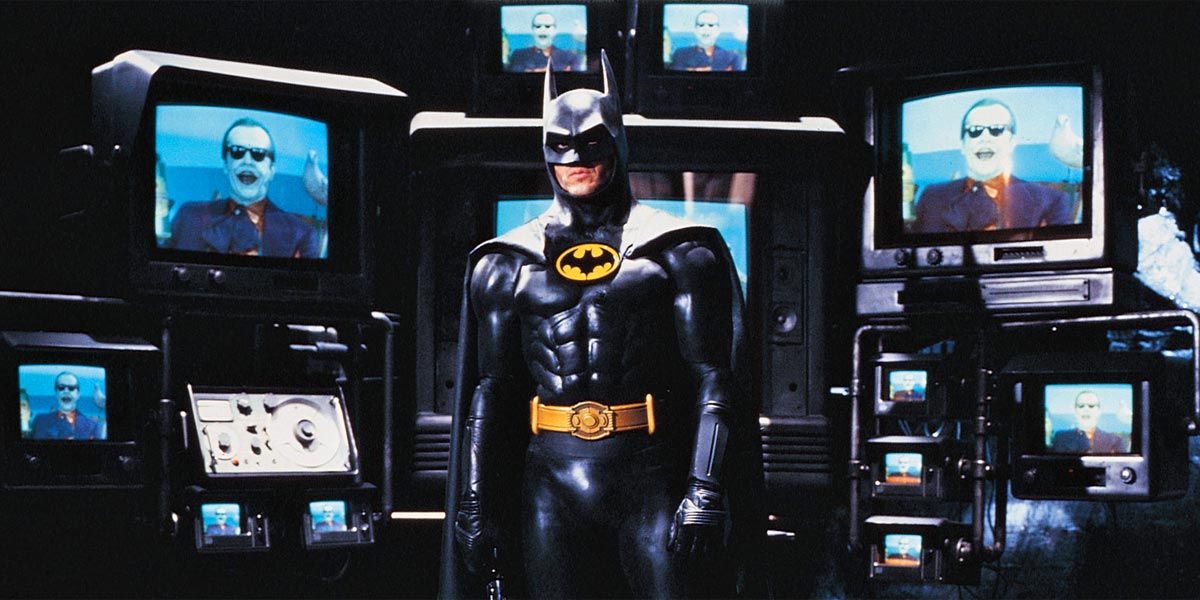 Michael Keaton as Batman in Batman (1989) with Joker in the background.