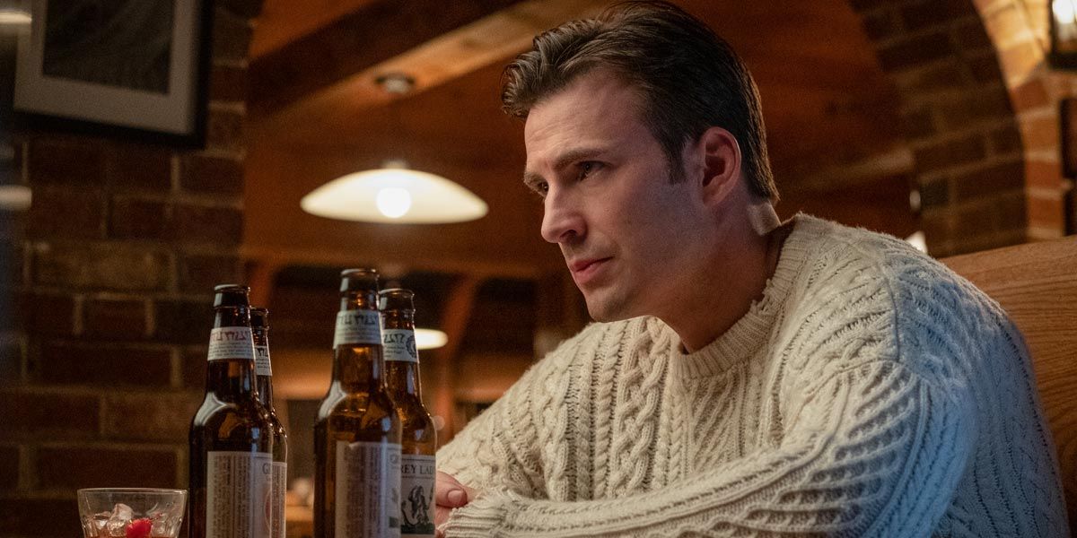 Chris Evans' Knives Out character sits at a table with a stern expression