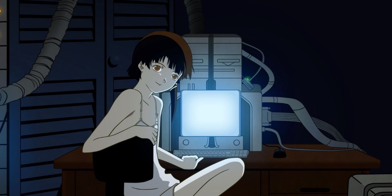 Lain in Serial Experiments Lain smiling at the viewer while sitting at a computer