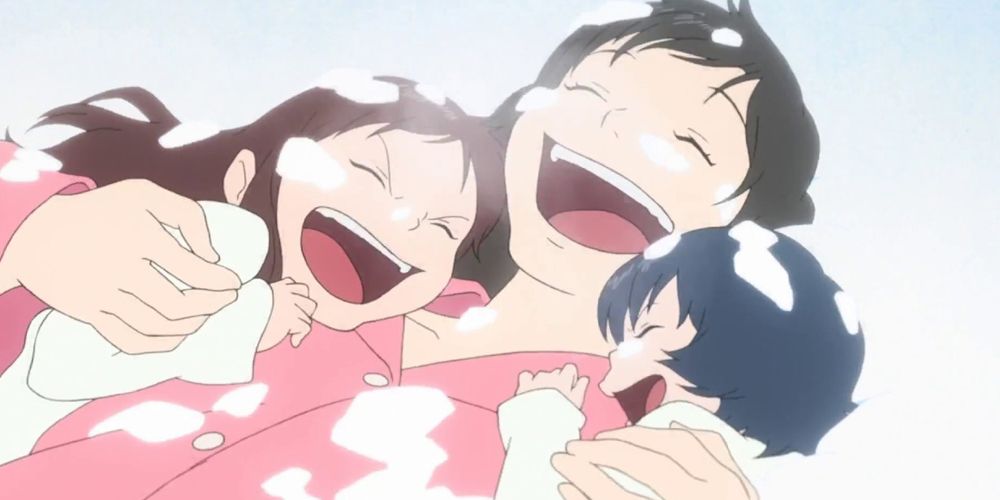 Mother plays with her children in the snow in Wolf Children.
