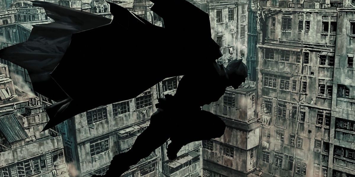 Batman in silhouette flies over Gotham City