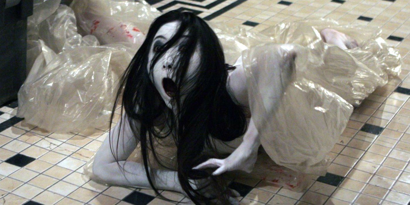 Kayako Saeki rasteja no chão de um banheiro no Grudge