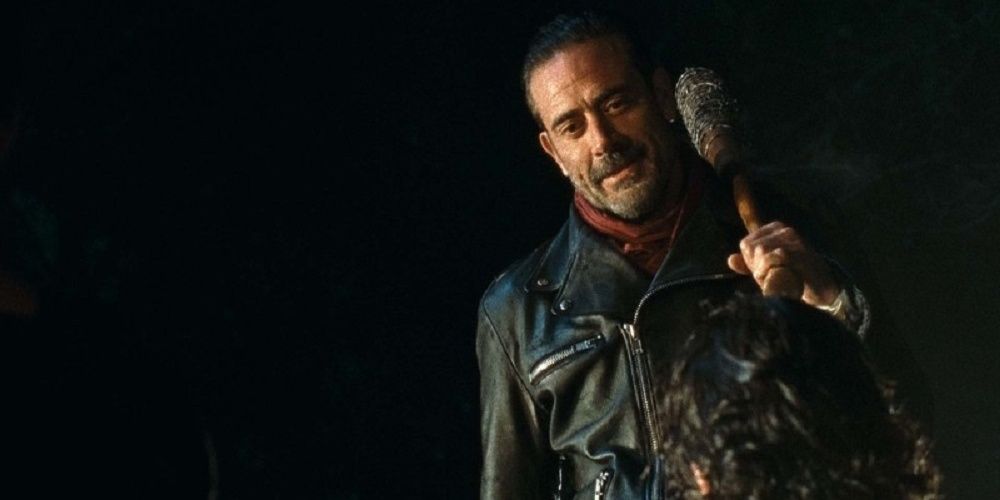 Negan, holding Lucille over his shoulder, looks down on Rick and his group before selecting someone to kill in "Last Day on Earth" in The Walking Dead.