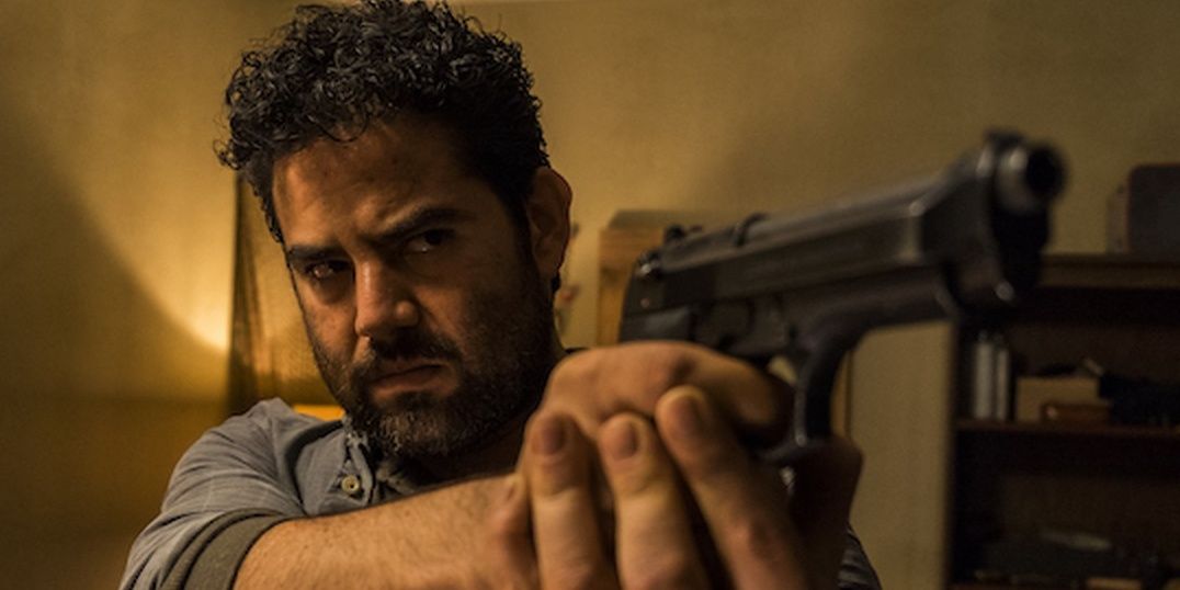 Morales points his gun at Rick and Daryl in "Monsters" in The Walking Dead.