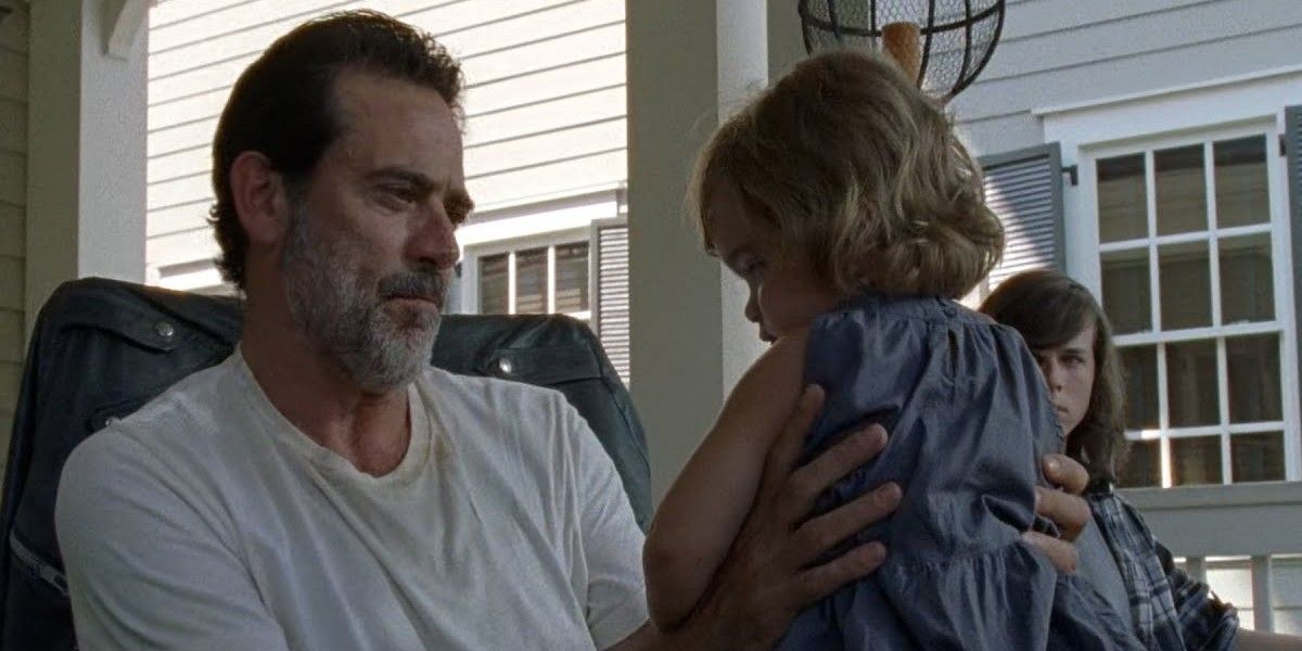 Negan (Jeffrey Dean Morgan) holding baby Judith as Carl watches in The Walking Dead