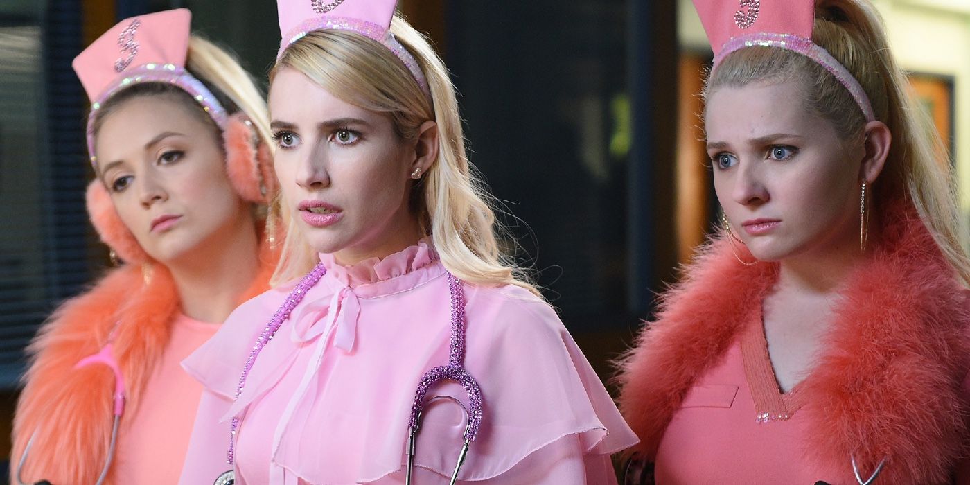 Emma Roberts dressed in pink nurse attire centered between two other nurses