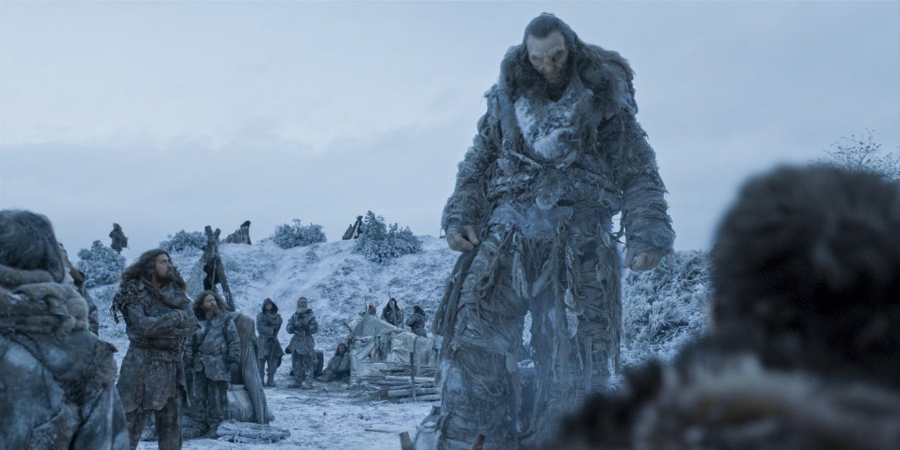 Wildlings and a giant standing the snow north of the wall in HBO's Game of Thrones