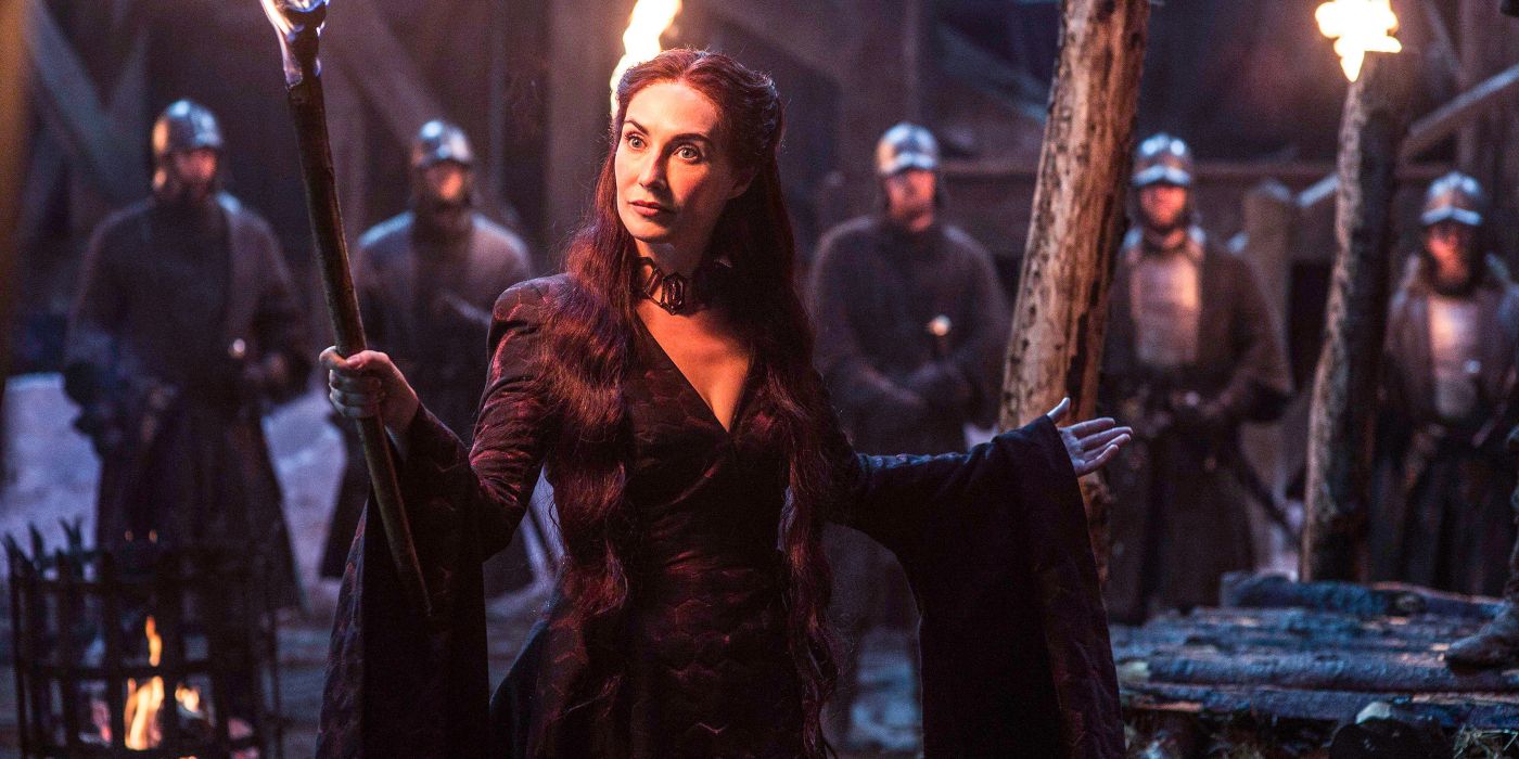 Melisandre in front of men holding torches in Game of Thrones.