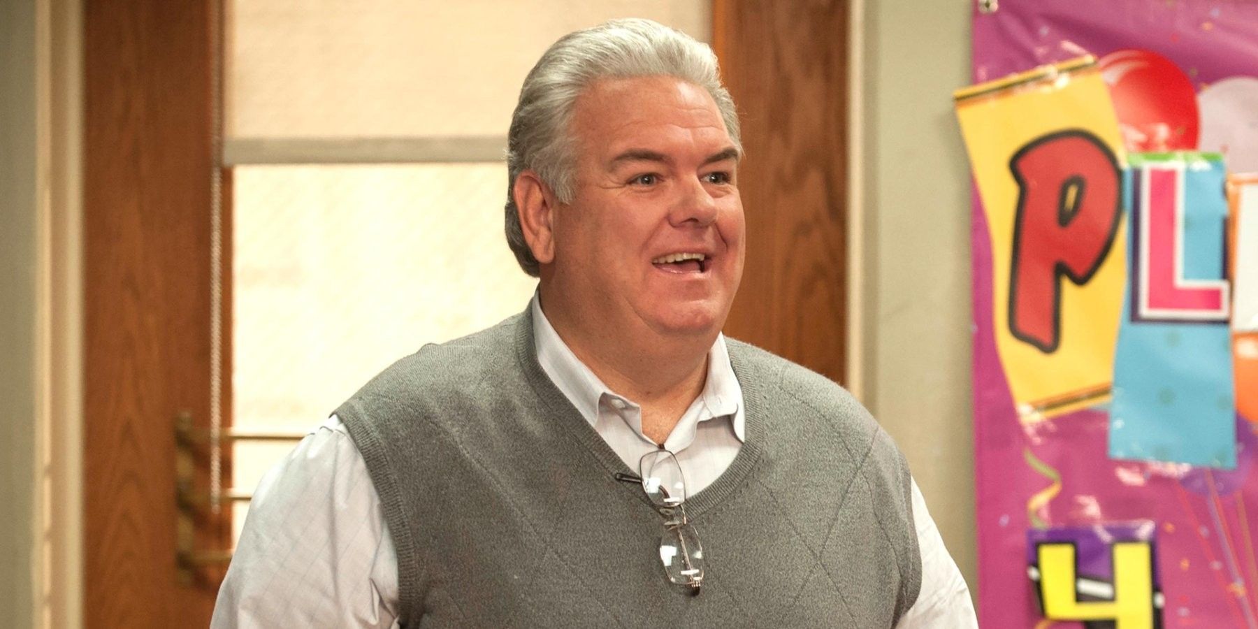 Jerry Gergich from Park and Rec smiling with glasses tucked into his sweatervest.