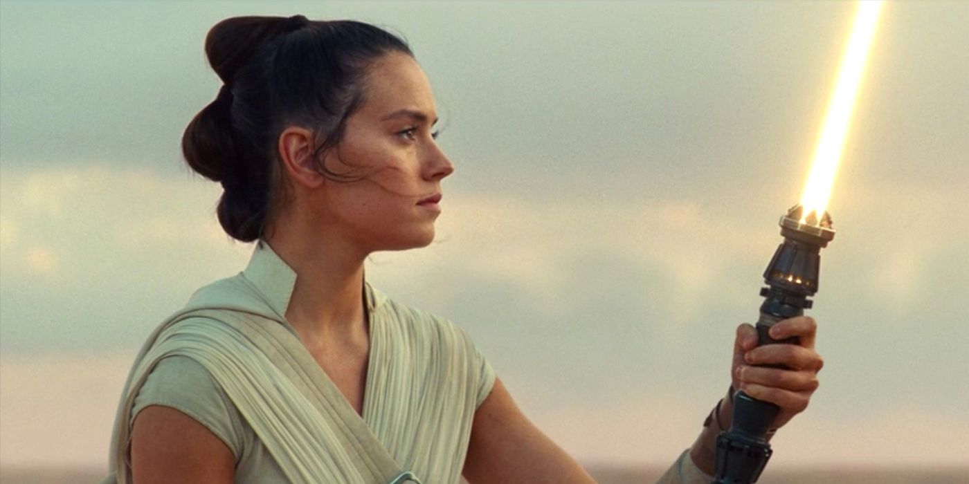 Rey holding her new yellow lightsaber at the end of Rise of Skywalker.