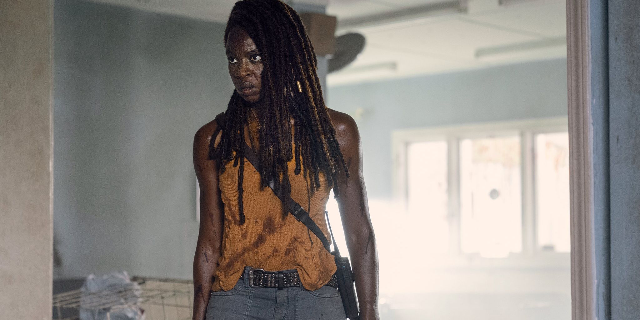 TWD's Michonne standing in a room with a determined expression on her face