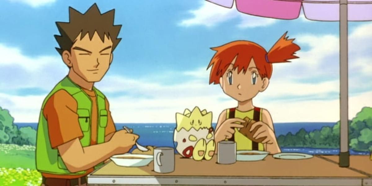 Brock and Misty sitting at a table eating