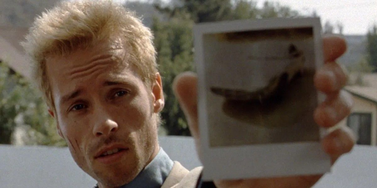 Guy Pearce as Leonard showing a photo to the camera in Memento